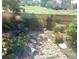 View from window of the backyard featuring a rock garden, flowering plants, a wooden fence and greenery at 10472 Longleaf Dr, Parker, CO 80134