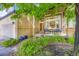 Inviting front porch with seating, complemented by lush landscaping and brick accents at 10472 Longleaf Dr, Parker, CO 80134