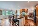 Sunlit kitchen features wood floors, island with bar seating, and stainless steel appliances at 10472 Longleaf Dr, Parker, CO 80134