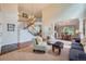 Bright living room boasts a staircase, hardwood floors, and seamlessly connects to the dining area at 10472 Longleaf Dr, Parker, CO 80134