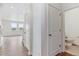 Well-lit hallway with hardwood floors leading to bright living space and bathroom at 18350 Prince Hill Cir, Parker, CO 80134