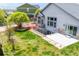 Backyard view featuring a walkout basement, patio, green lawn, mature trees, and privacy fence at 9060 Ferncrest St, Firestone, CO 80504
