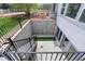 View from backyard staircase with metal railings showing walkout basement entrance with sliding glass doors at 9060 Ferncrest St, Firestone, CO 80504