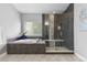 Stylish bathroom featuring a glass-enclosed shower, soaking tub, and neutral color palette at 9060 Ferncrest St, Firestone, CO 80504