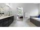 Bright bathroom showcasing a soaking tub, black cabinets, and a glimpse into the Primary bedroom at 9060 Ferncrest St, Firestone, CO 80504