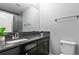 Modern bathroom featuring dark granite counters, a sleek sink, and a convenient toilet at 9060 Ferncrest St, Firestone, CO 80504