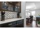 Kitchen detail showcasing cabinetry, countertops, a coffee maker, and access to the dining room at 9060 Ferncrest St, Firestone, CO 80504