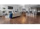 Open-concept living room showcasing a fireplace, hardwood flooring, and connection to the kitchen area at 9060 Ferncrest St, Firestone, CO 80504