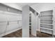 Spacious walk-in closet with custom shelving and ample storage space with hardwood floors at 9060 Ferncrest St, Firestone, CO 80504