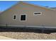 Side view of a home with beige vinyl siding, a dark shingle roof and a landscaped yard with gravel and a sidewalk at 15603 E 51St Pl, Denver, CO 80239