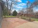 Landscaped backyard with stone patio, grassy area, mature trees and privacy fence at 9639 W 63Rd Pl, Arvada, CO 80004