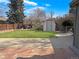 Large backyard featuring grass, stone patio, a shed, and a fenced perimeter at 9639 W 63Rd Pl, Arvada, CO 80004