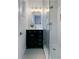 Stylish bathroom with walk-in glass shower, white herringbone tile, and modern black vanity at 9639 W 63Rd Pl, Arvada, CO 80004