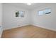 Clean bedroom features two windows, neutral walls, wood floors, and white trim at 9639 W 63Rd Pl, Arvada, CO 80004