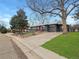 Charming gray home featuring a red front door, attached garage, mature trees, and a well-maintained front lawn at 9639 W 63Rd Pl, Arvada, CO 80004
