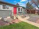 Charming gray home with a bright red front door, complemented by manicured landscaping and a welcoming walkway at 9639 W 63Rd Pl, Arvada, CO 80004