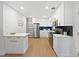 Bright kitchen features white cabinets, stainless appliances, black backsplash, and light wood floors at 9639 W 63Rd Pl, Arvada, CO 80004