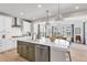 Kitchen island featuring white quartz countertops, decorative wood cabinets, stainless steel appliances, and pendant lighting at 821 Boulder Peak Ave, Erie, CO 80516