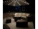 Patio with cushioned outdoor seating area under umbrella with string lights for cozy evenings at 821 Boulder Peak Ave, Erie, CO 80516