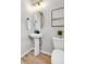 Clean, modern powder room with pedestal sink, oval mirror, and neutral decor at 821 Boulder Peak Ave, Erie, CO 80516