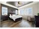 Comfortable bedroom featuring a dark wood bed frame, accent wall, and bright windows with shutters at 9915 E 162Nd Pl, Brighton, CO 80602