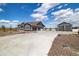 Charming single Gathering home with a long concrete driveway, manicured lawn, an oversized garage, and beautiful blue sky at 9915 E 162Nd Pl, Brighton, CO 80602