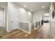 Upstairs hallway with hardwood floors, white trim, and decorative wall art, connecting various rooms at 9915 E 162Nd Pl, Brighton, CO 80602