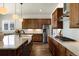 The kitchen features stainless steel appliances, granite counters, a spacious island, and beautiful hardwood floors at 9915 E 162Nd Pl, Brighton, CO 80602