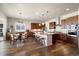 Open-concept kitchen with wood cabinets, granite countertops, an island, and stainless steel appliances at 9915 E 162Nd Pl, Brighton, CO 80602