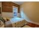 Charming bedroom features exposed brick accent wall and hardwood floors at 132 Delaware St, Denver, CO 80223