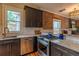 Updated kitchen features granite countertops, stainless steel appliances, and exposed brick accent wall at 132 Delaware St, Denver, CO 80223