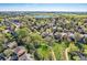 Expansive aerial view of a neighborhood with lush greenery, homes, and a serene lake in the background at 10963 Bryant St, Westminster, CO 80234