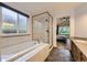 Bright bathroom with soaking tub, glass-enclosed shower, and tiled flooring at 10963 Bryant St, Westminster, CO 80234