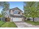 Charming two-story home features a driveway, attached two-car garage, and mature trees at 10963 Bryant St, Westminster, CO 80234