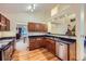 Well-lit kitchen with wood cabinets, black countertops, stainless steel appliances, and wood floors, offering both style and functionality at 10963 Bryant St, Westminster, CO 80234