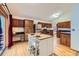 Bright kitchen with wood cabinets, center island with seating, stainless steel appliances, and wood floors at 10963 Bryant St, Westminster, CO 80234