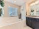 Soaking tub in a bright bathroom with large window and stylish décor at 11902 Norfolk Ct, Commerce City, CO 80022