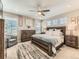 Beautifully staged bedroom with large bed, ceiling fan, and ample natural light at 11902 Norfolk Ct, Commerce City, CO 80022
