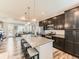 Open concept living space with kitchen island and granite countertops and stainless steel appliances at 11902 Norfolk Ct, Commerce City, CO 80022