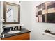 Updated powder room features a granite countertop and stylish framed mirror at 443 Garfield St, Denver, CO 80206