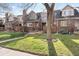 Charming townhome with red brick exterior, manicured lawn and mature trees at 443 Garfield St, Denver, CO 80206