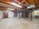 Unfinished basement with overhead lighting, utilities, and painted concrete floors at 6898 W Nova Dr, Littleton, CO 80128