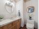 Charming powder room with decorative wallpaper, framed mirrors, and stylish fixtures at 6898 W Nova Dr, Littleton, CO 80128