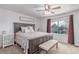 Comfortable bedroom with decorative wood headboard, bench, fan, side table and a view of the outdoors at 3186 W Indian Summer Ln, Castle Rock, CO 80109