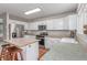 Functional kitchen with white cabinetry, stainless steel appliances, wood floors, and a tile center island at 3186 W Indian Summer Ln, Castle Rock, CO 80109