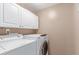 Efficient laundry room features a washer, dryer, and white cabinetry for storage at 3186 W Indian Summer Ln, Castle Rock, CO 80109
