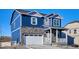 Charming two-story home with blue siding, stone accents, a two-car garage and covered front porch at 758 N Clubview St, Watkins, CO 80137