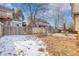 Large backyard featuring partial snow cover, a tall wooden fence, and a quaint patio seating area at 3575 S Waco St, Aurora, CO 80013