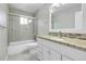 Bright bathroom featuring tiled shower over tub, single vanity with granite countertop at 3575 S Waco St, Aurora, CO 80013