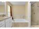 Bathroom featuring a soaking tub with tile surround, vanity with granite countertop and a shower with glass door at 3575 S Waco St, Aurora, CO 80013